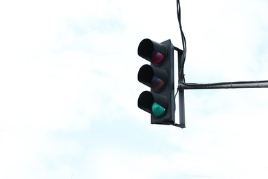 Photo of Traffic light in city against cloudy sky outdoors