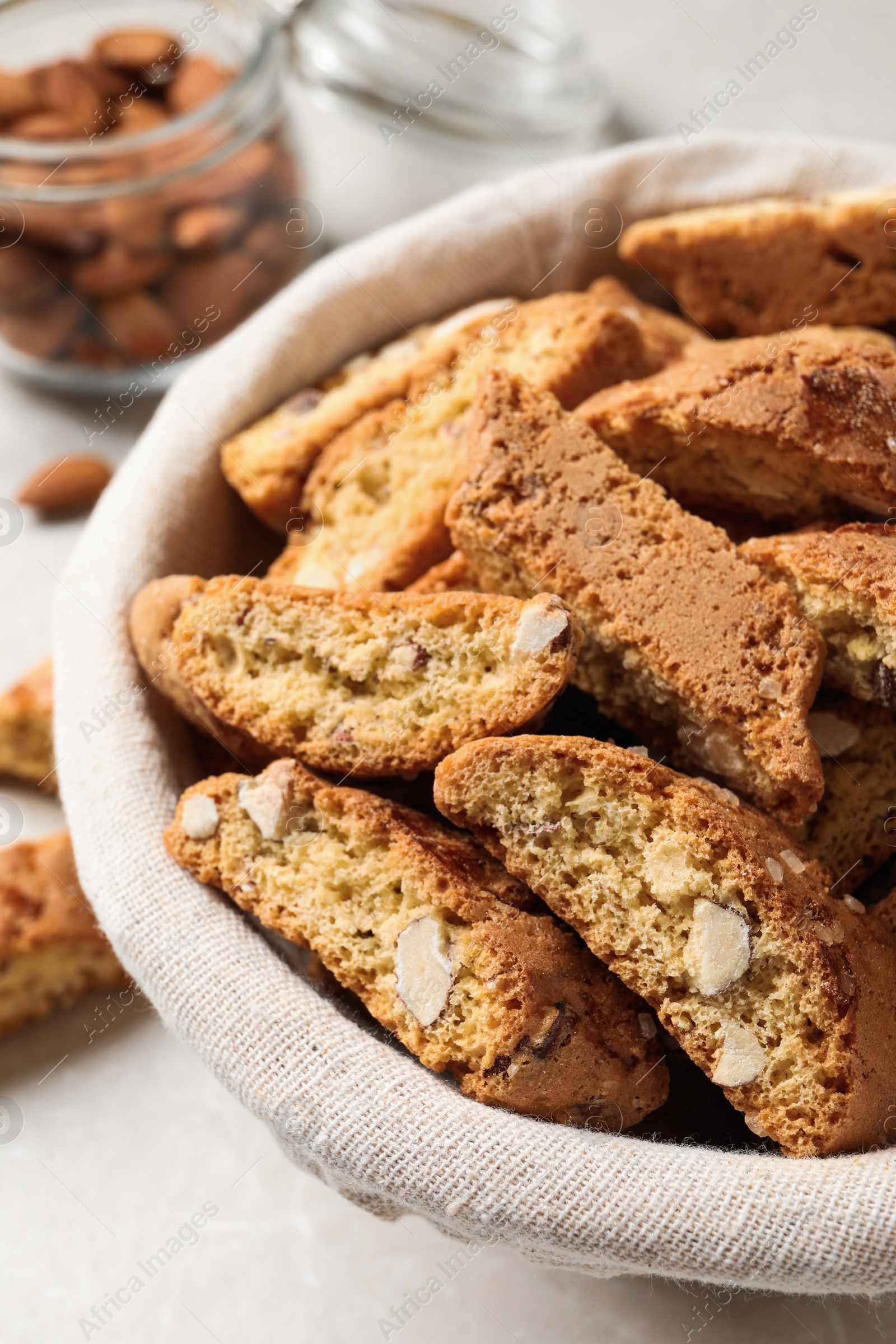 Photo of Traditional Italian almond biscuits (Cantucci) in basket on table, closeup