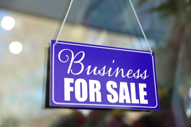 Image of Blue sign with Business For Sale hanging on glass door