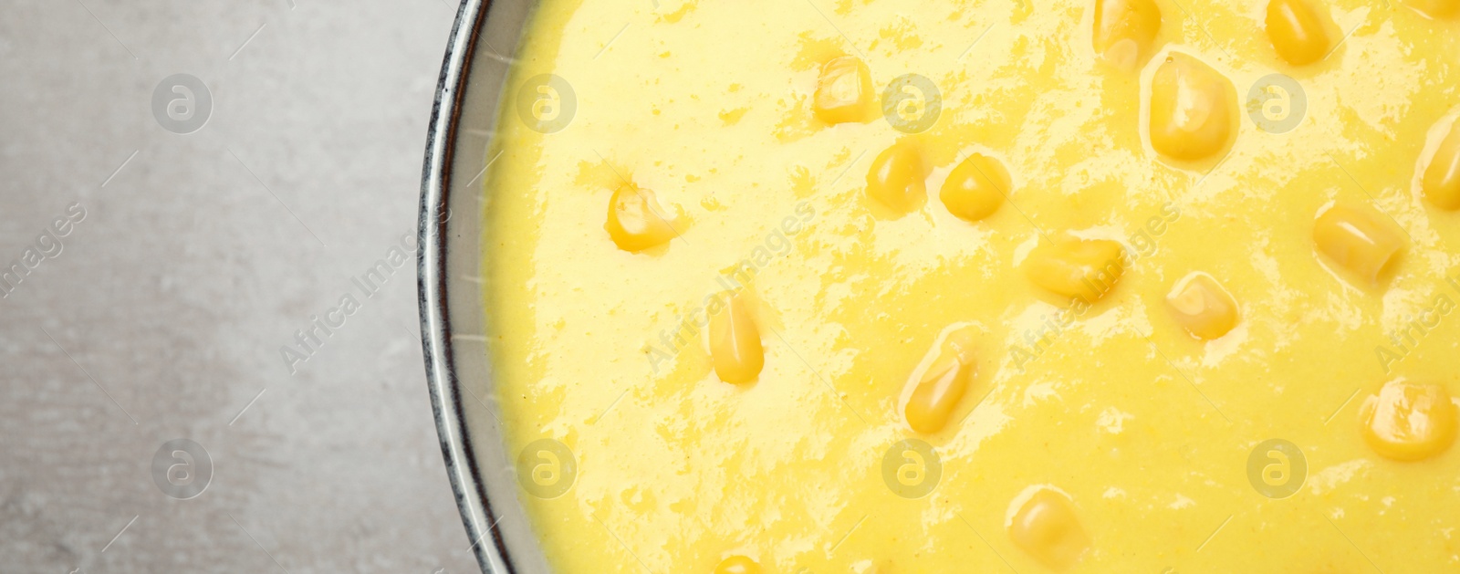 Photo of Delicious creamy corn soup on grey table, top view