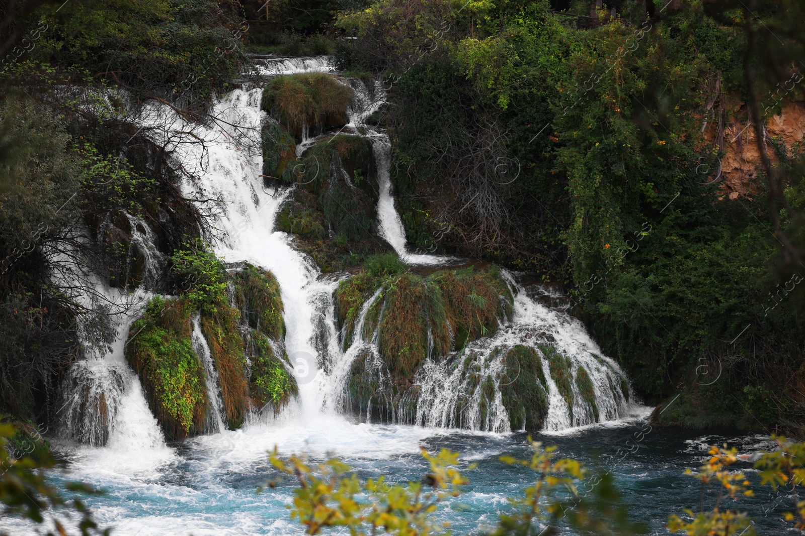 Photo of Picturesque view of beautiful waterfall and rocks outdoors