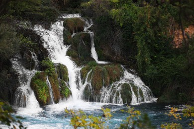 Photo of Picturesque view of beautiful waterfall and rocks outdoors