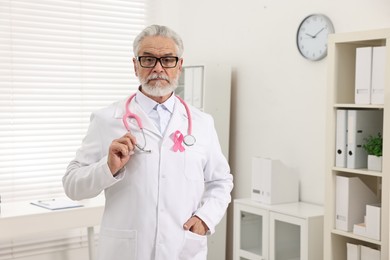 Photo of Mammologist with pink ribbon in hospital. Breast cancer awareness