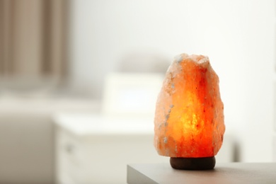 Himalayan salt lamp on table indoors, space for text