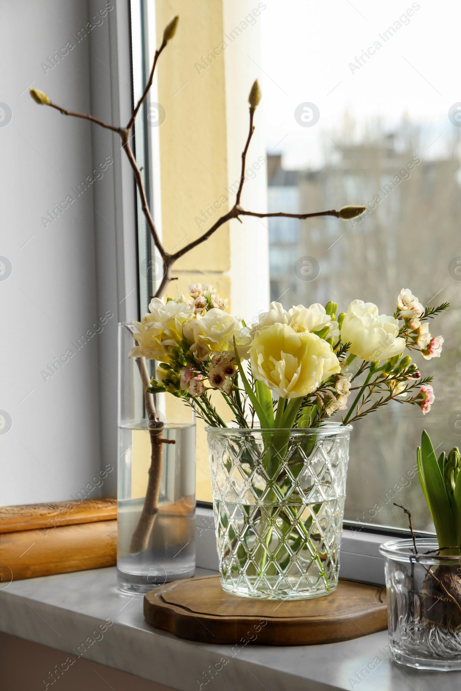 Photo of Beautiful spring flowers in vase on windowsill indoors