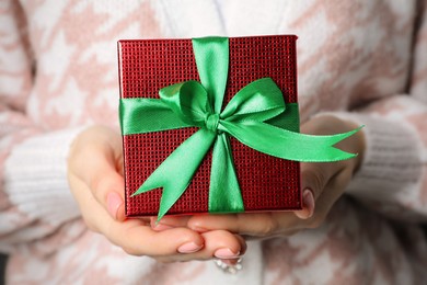 Christmas present. Woman holding beautifully wrapped gift box, closeup