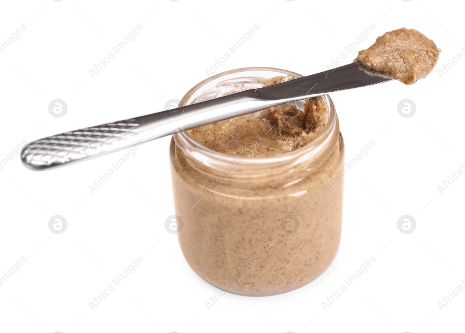 Photo of Tasty nut paste in jar and knife isolated on white