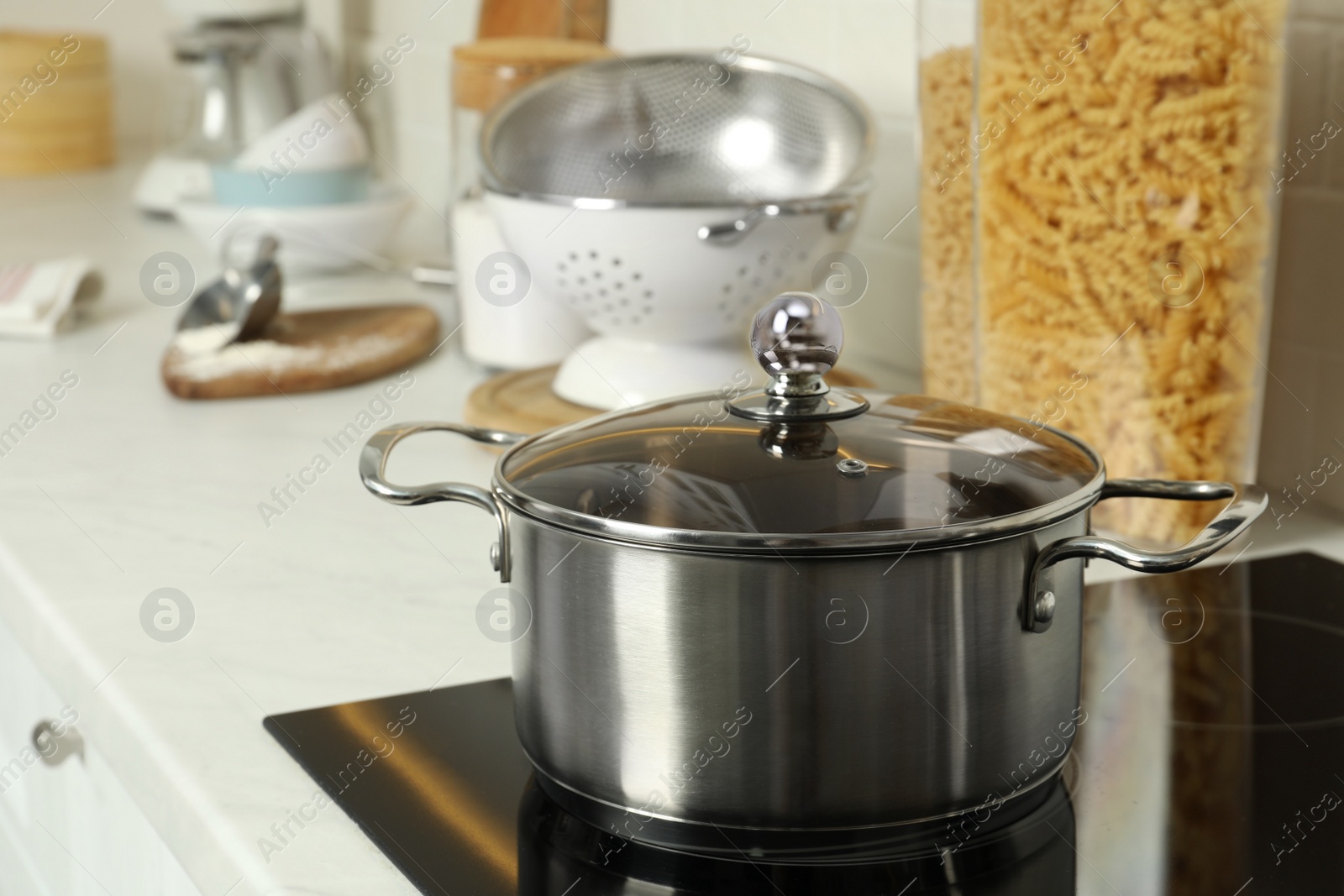 Photo of Shiny pot on electric stove in kitchen. Cooking utensil