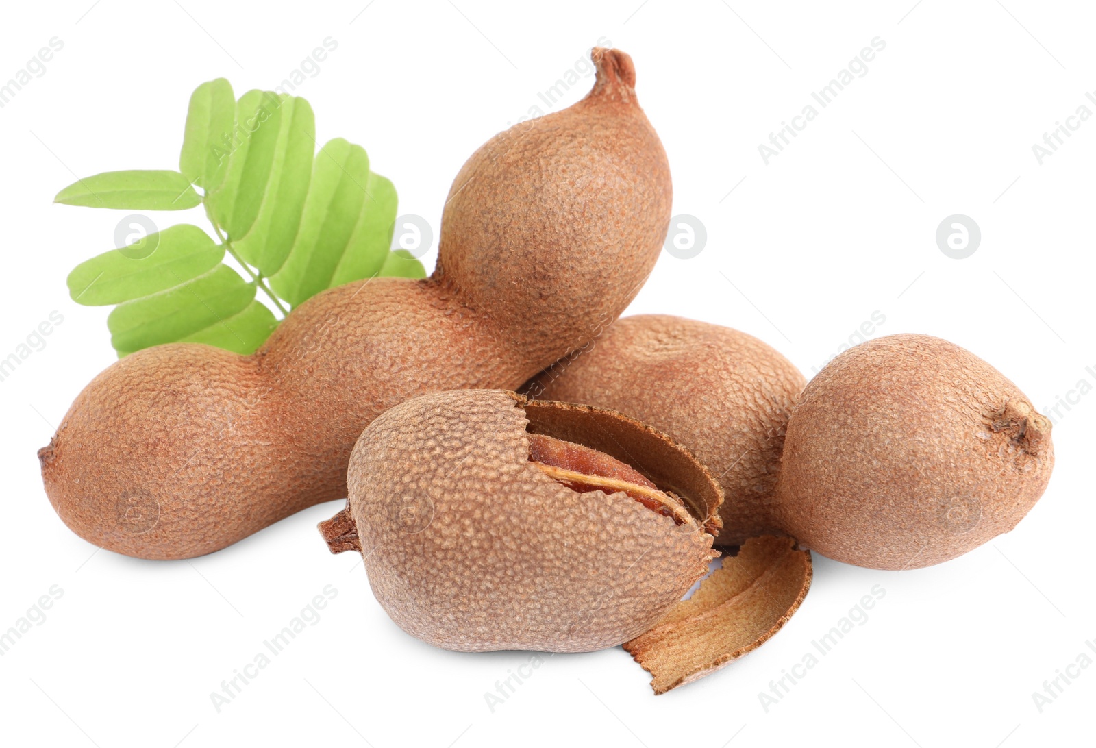 Photo of Delicious ripe tamarinds with leaves on white background. Exotic fruit