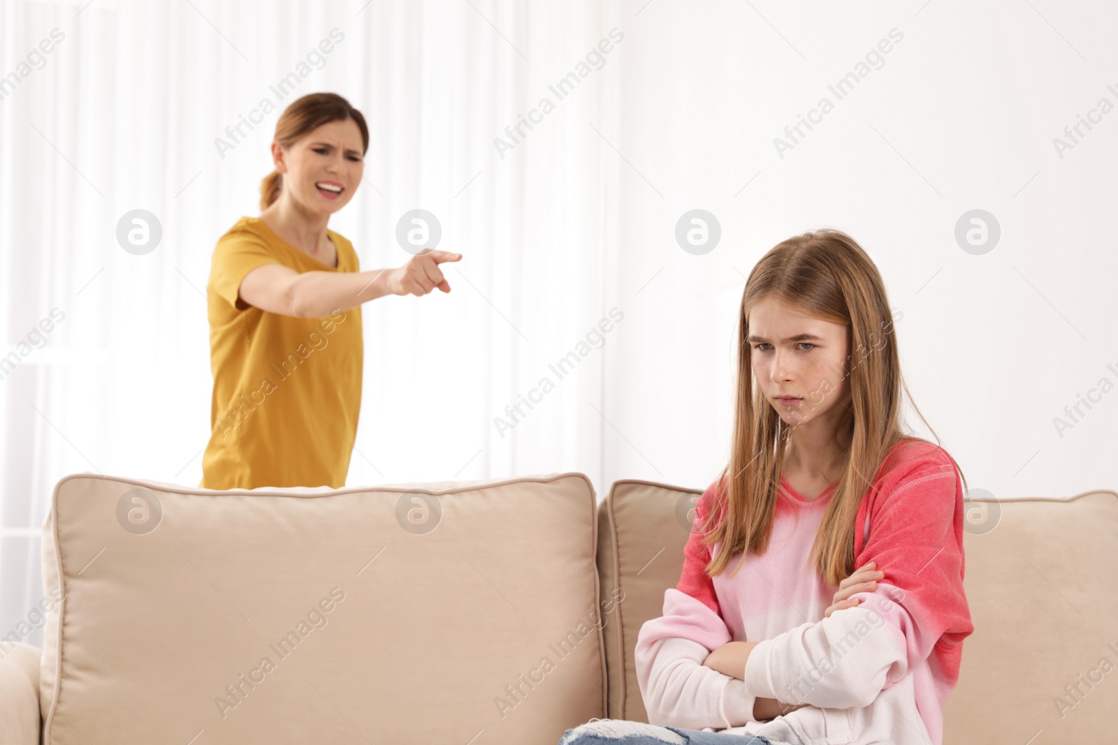 Photo of Mother scolding her teenager daughter at home