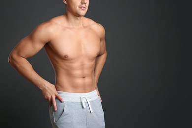 Photo of Man with sexy body on grey background, closeup. Space for text