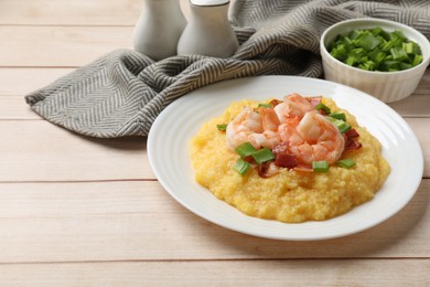 Photo of Plate with fresh tasty shrimps, bacon, grits and green onion on light wooden table, space for text