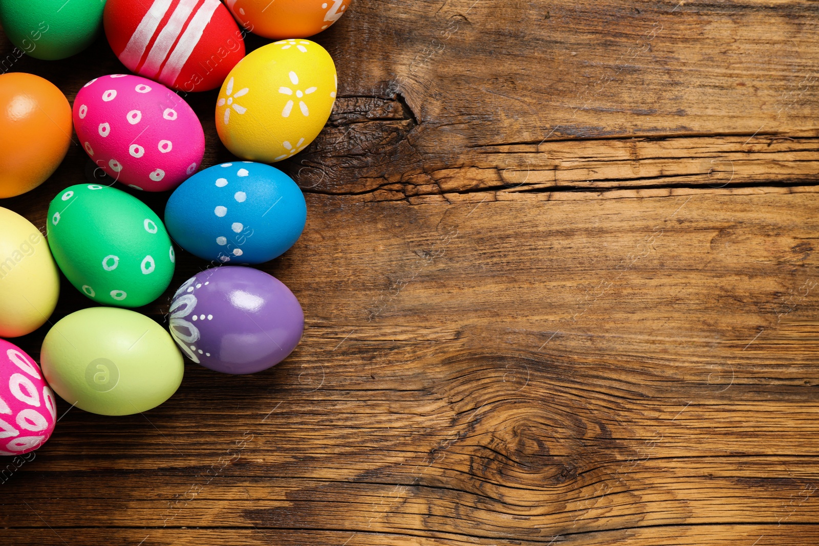 Photo of Colorful Easter eggs on wooden background, flat lay. Space for text