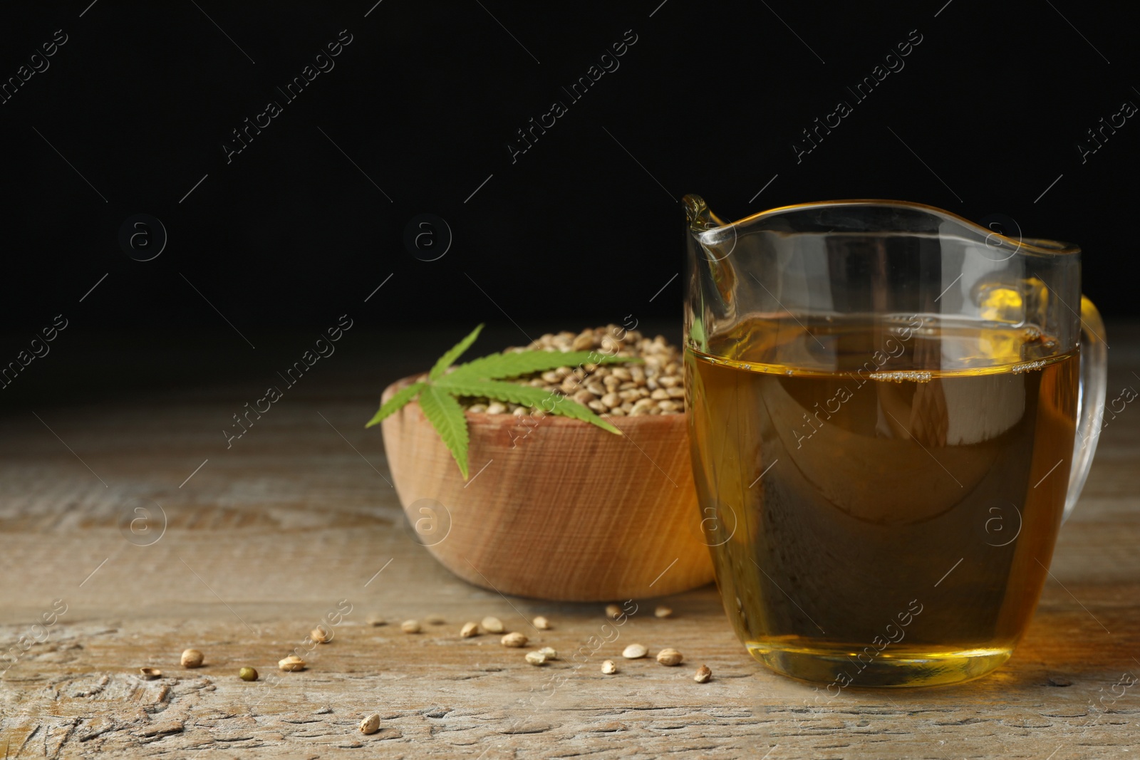 Photo of Composition with hemp oil on wooden table