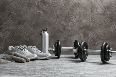 Photo of Composition with dumbbells and fitness accessories on floor. Space for text