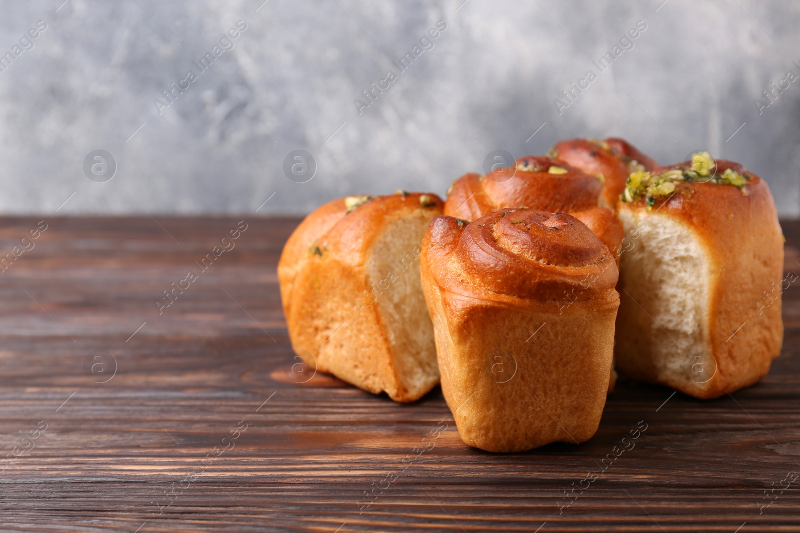 Photo of Tasty fresh pampushky. Traditional Ukrainian buns with garlic on wooden table, space for text