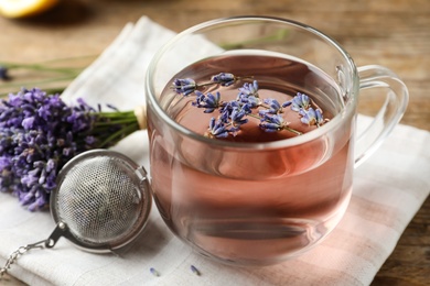 Fresh delicious tea with lavender in glass cup on wooden table