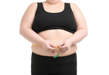 Overweight woman with measuring tape on white background