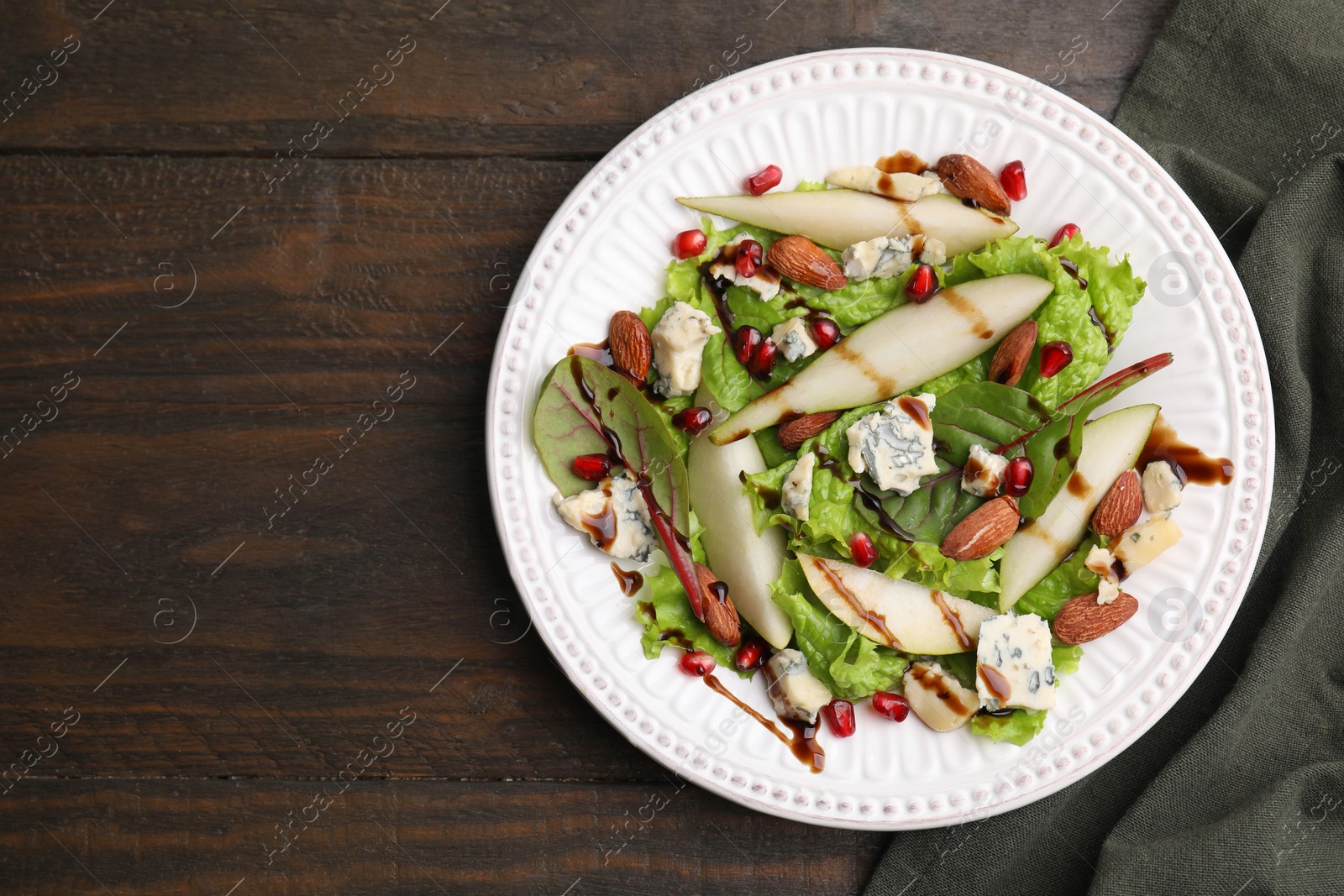 Photo of Delicious pear salad with sauce on wooden table, top view. Space for text