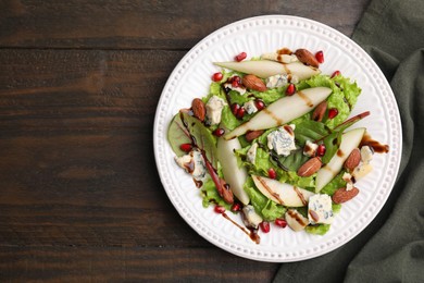 Photo of Delicious pear salad with sauce on wooden table, top view. Space for text