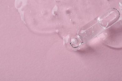 Photo of Pipette with cosmetic serum on pink background, above view. Space for text