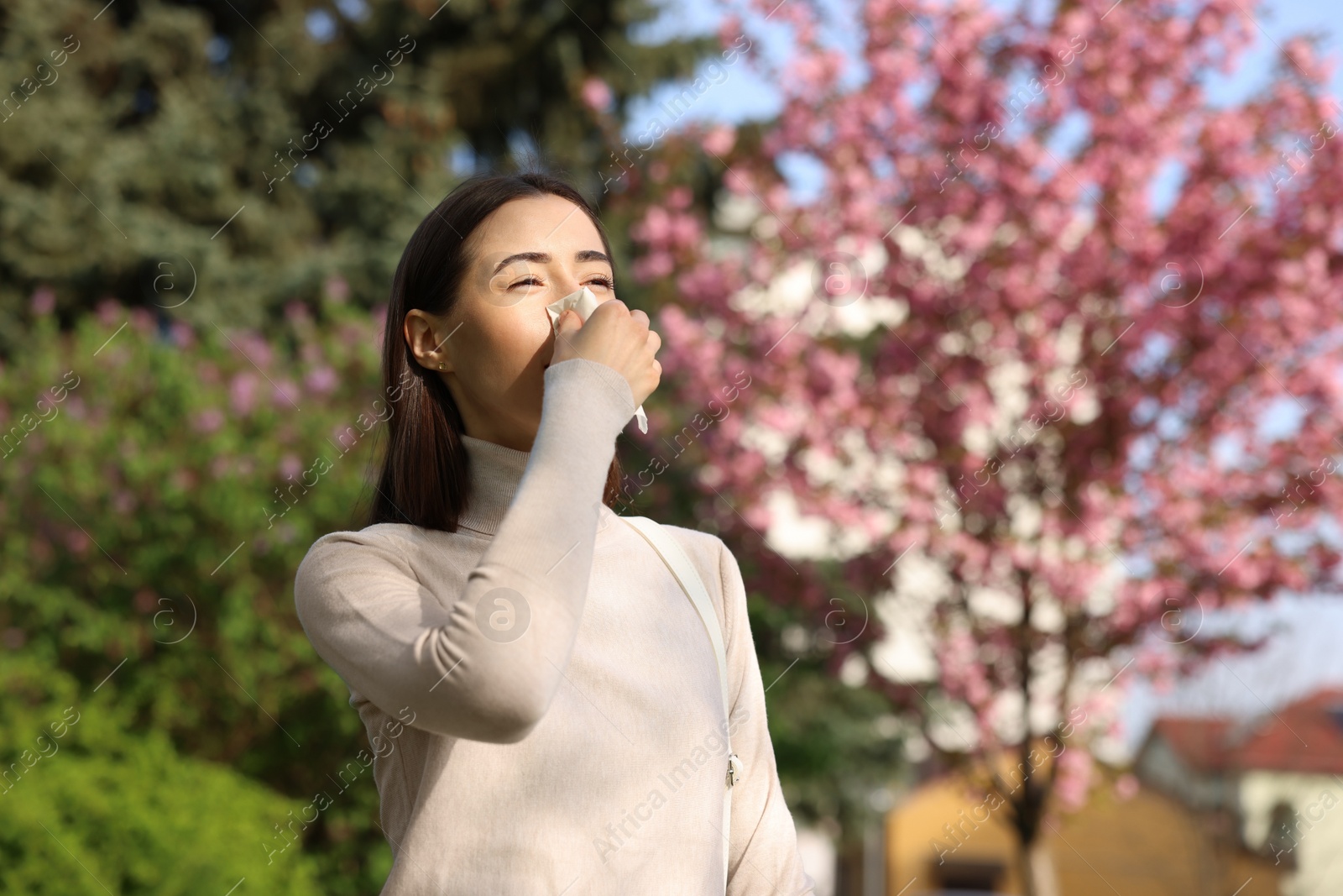 Photo of Woman with napkin suffering from seasonal allergy on spring day