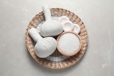 Photo of Composition with herbal massage bags and other spa products on light grey marble table, top view