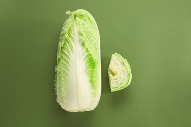 Photo of Whole and cut fresh Chinese cabbages on olive background, flat lay