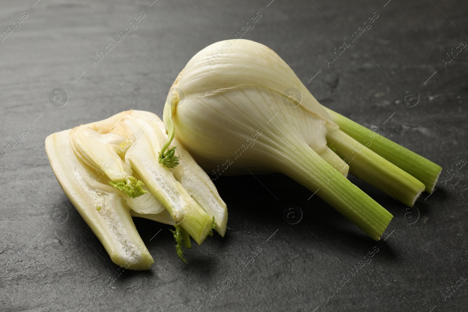 Photo of Fresh raw fennel bulbs on gray table, closeup