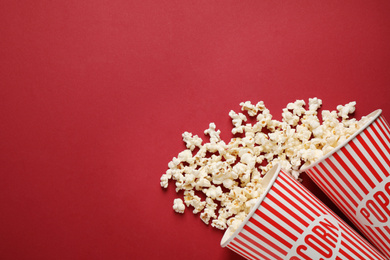 Photo of Flat lay composition with delicious popcorn on red background. Space for text