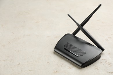 Photo of Modern Wi-Fi router on light background. Space for text