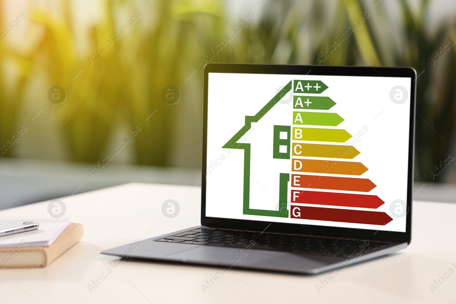 Image of Energy efficiency rating on laptop display. Workplace with modern computer