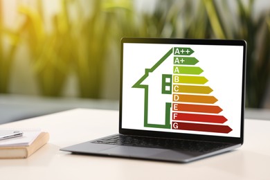 Image of Energy efficiency rating on laptop display. Workplace with modern computer