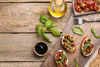 Delicious bruschettas with balsamic vinegar and toppings served on wooden table, flat lay. Space for text