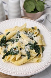 Photo of Tasty pasta with spinach and cheese on white table, closeup