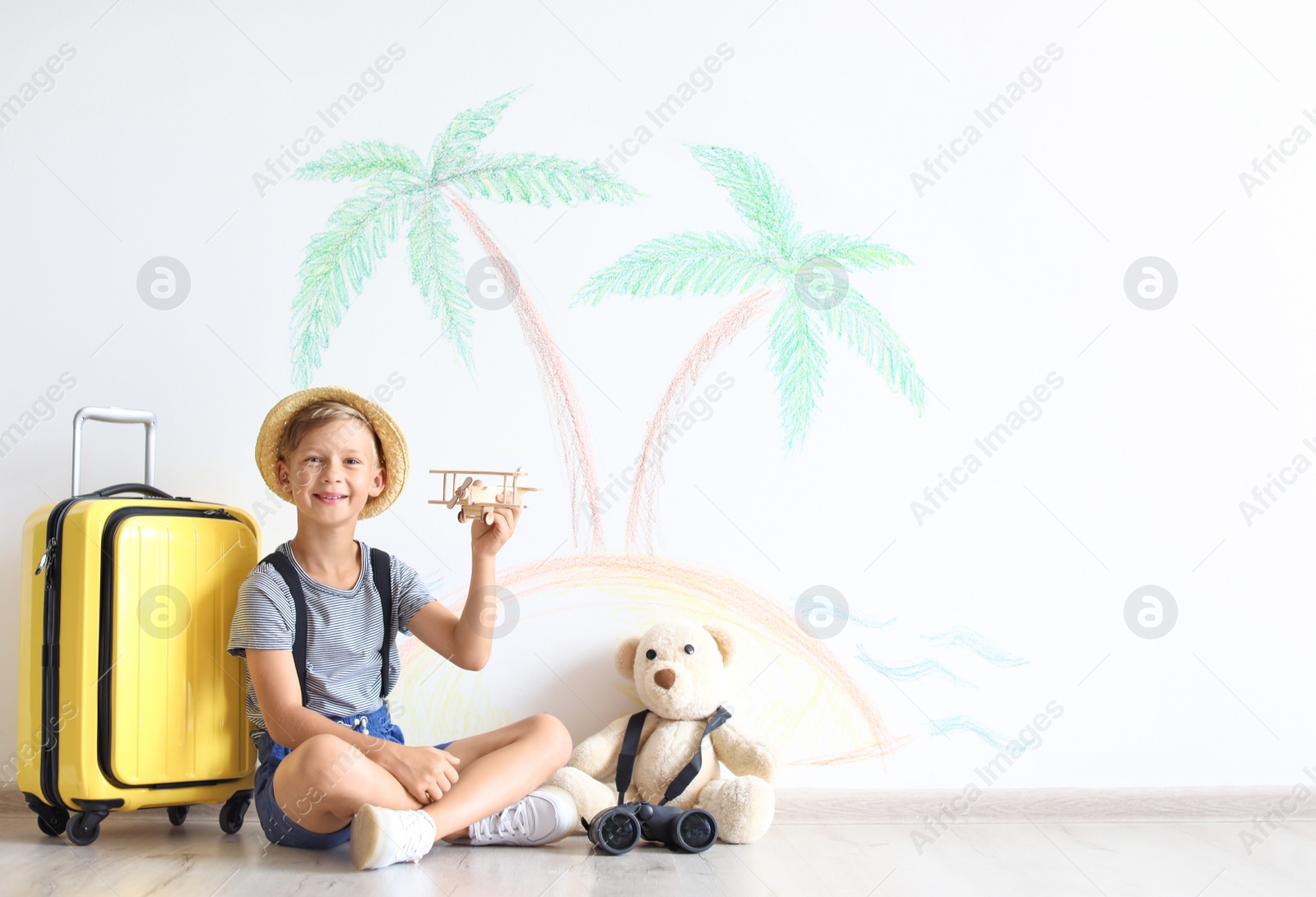 Photo of Adorable little child playing with toy airplane indoors