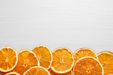 Photo of Many dry orange slices on white wooden table, flat lay. Space for text