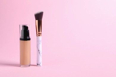 Photo of Bottle of skin foundation and brush on pink background, space for text. Makeup product