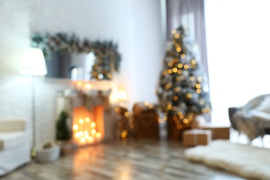 Photo of Blurred view of stylish interior with decorated Christmas tree and fireplace