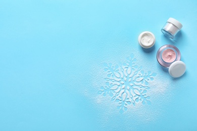Photo of Set of cosmetic products on blue background, flat lay with space for text. Winter care