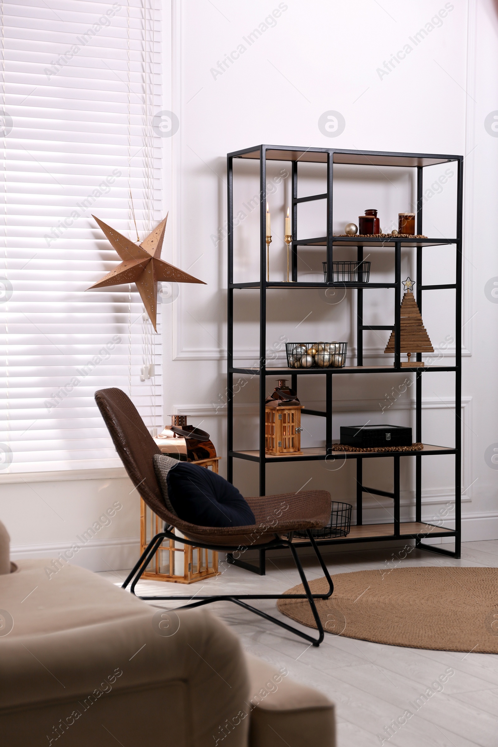 Photo of Stylish room interior with shelving unit and Christmas decor. Modern design