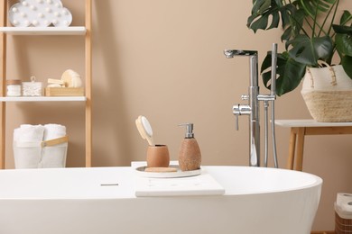 Different personal care products and accessories on bath tub in bathroom