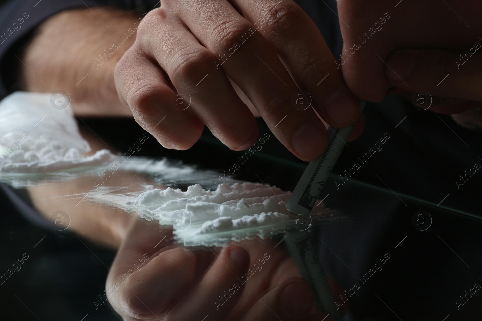 Photo of Drug addict taking cocaine at table, closeup view