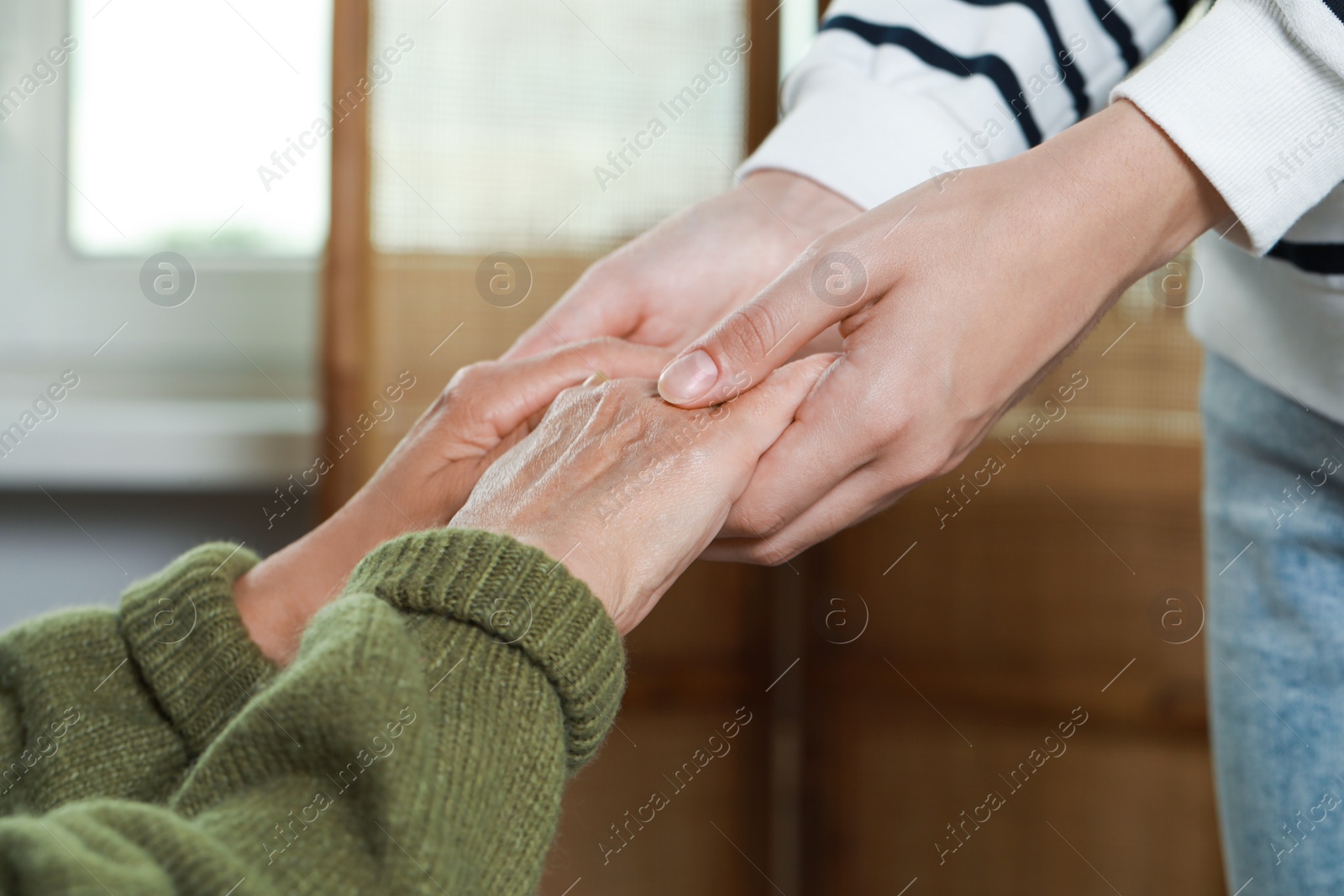 Photo of Caregiver helping elderly woman at home, closeup