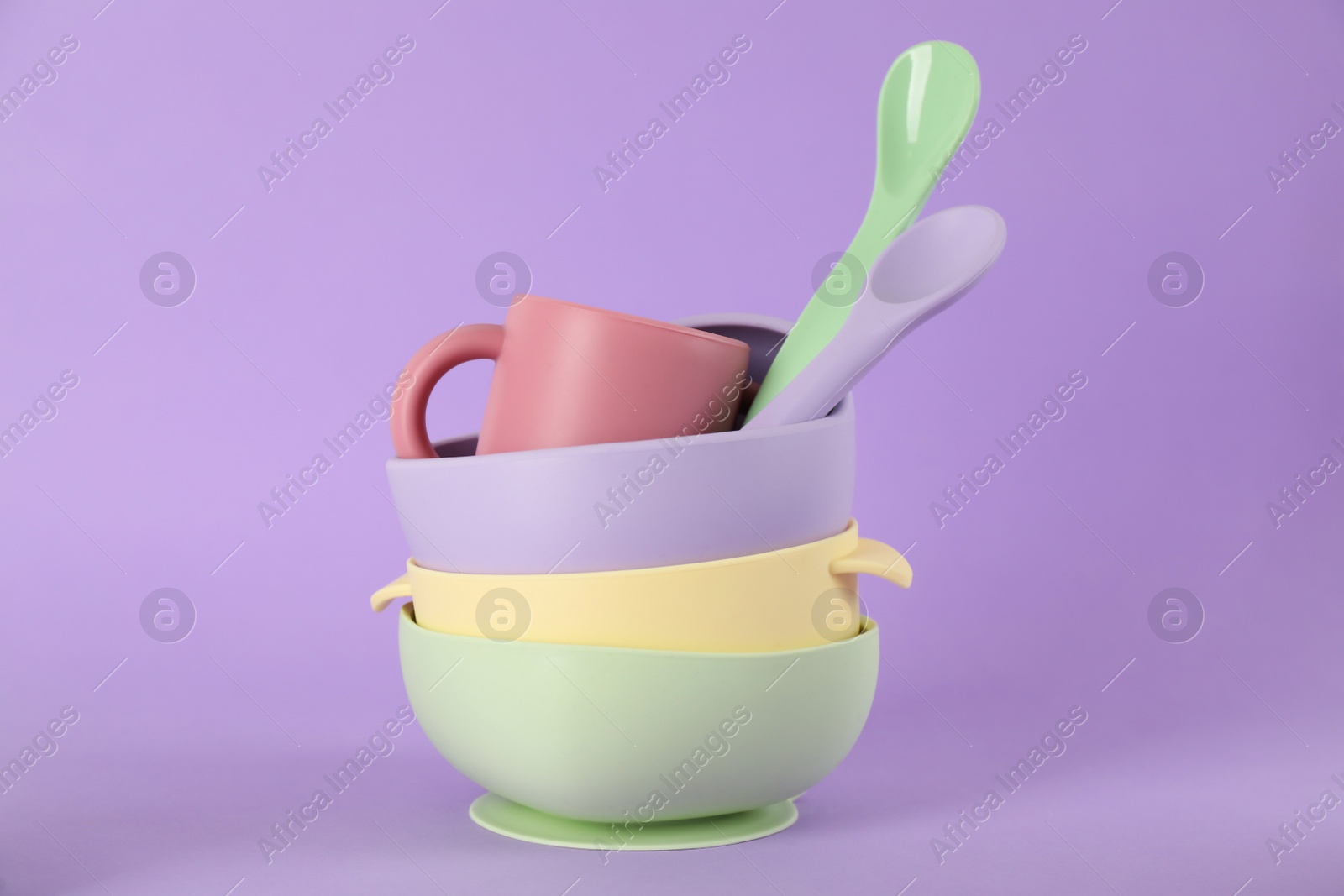 Photo of Set of plastic dishware on violet background. Serving baby food