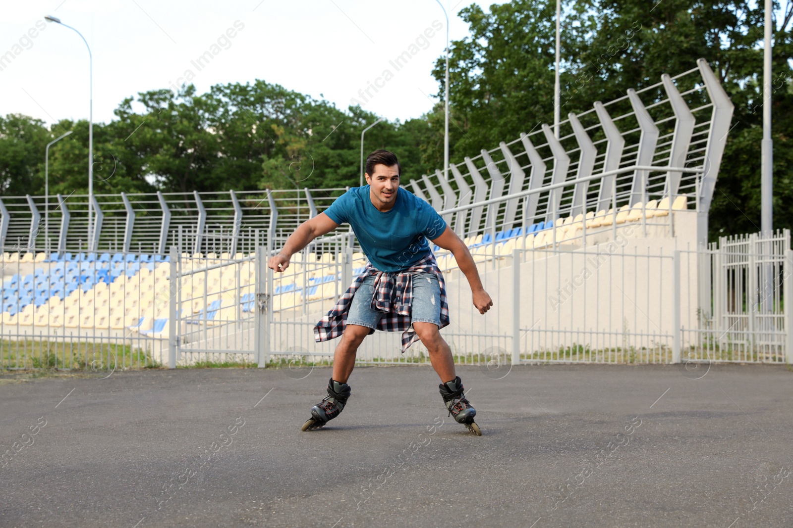 Photo of Handsome young man roller skating outdoors. Recreational activity