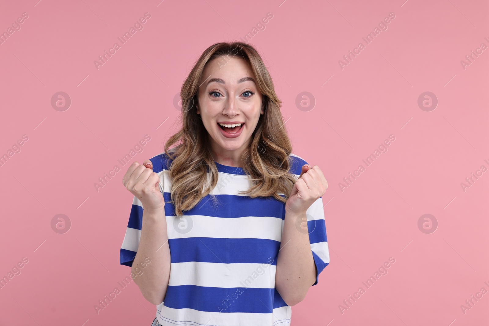 Photo of Portrait of happy surprised woman on pink background