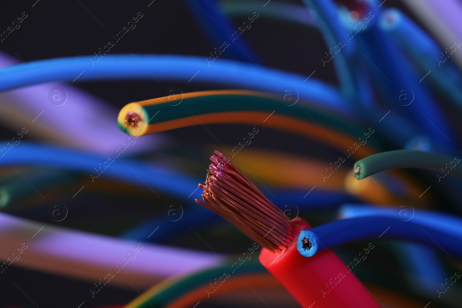 Photo of Colorful cables on blurred background, closeup. Electrician's supply