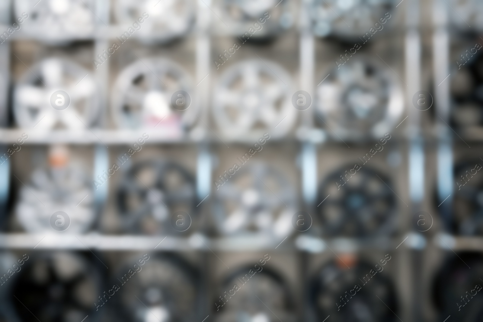 Photo of Blurred view of alloy wheels on racks in automobile service center