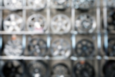 Blurred view of alloy wheels on racks in automobile service center